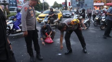 Kapolres Jember bersama anggotanya bahu membahu bergotong royong membersihkan sampah di jalan paska demo